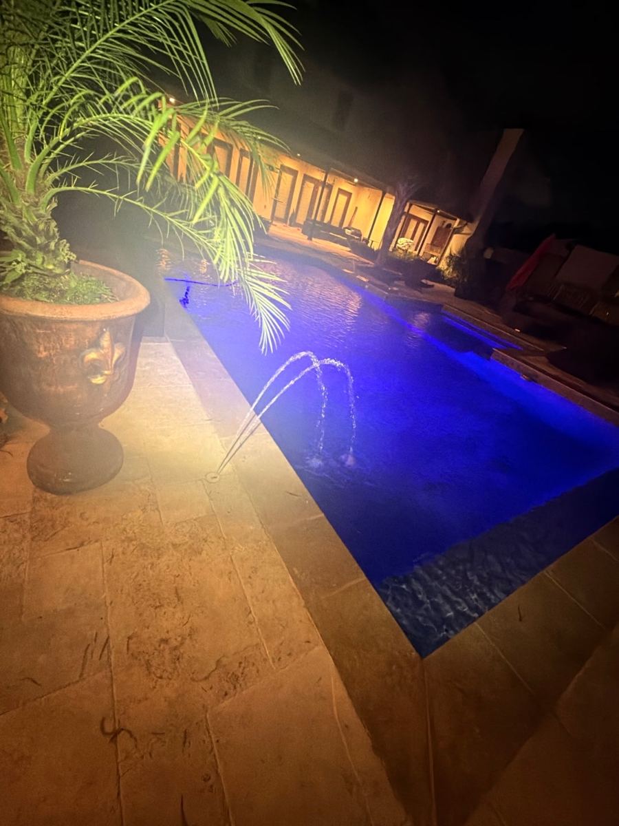 Featured pool lit blue at night
