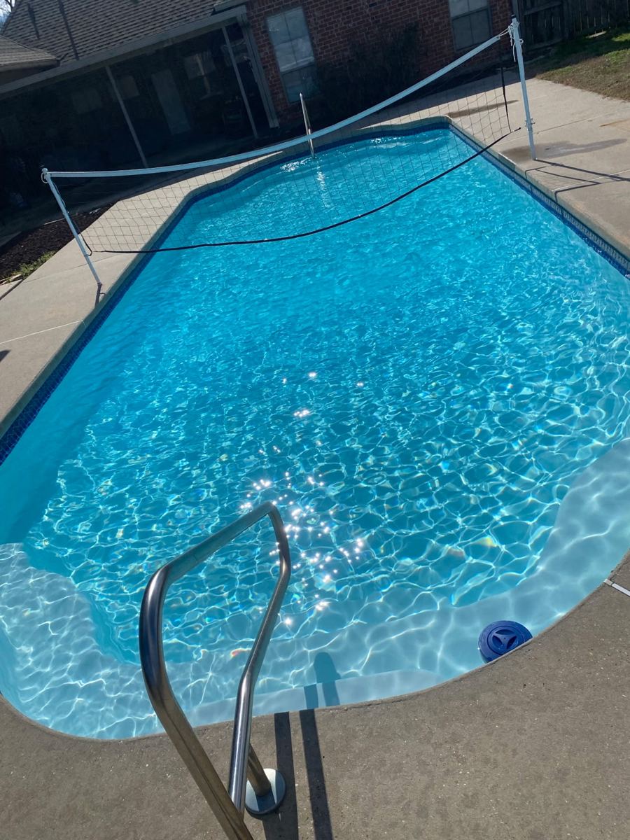 Clear blue backyard pool with volleyball net